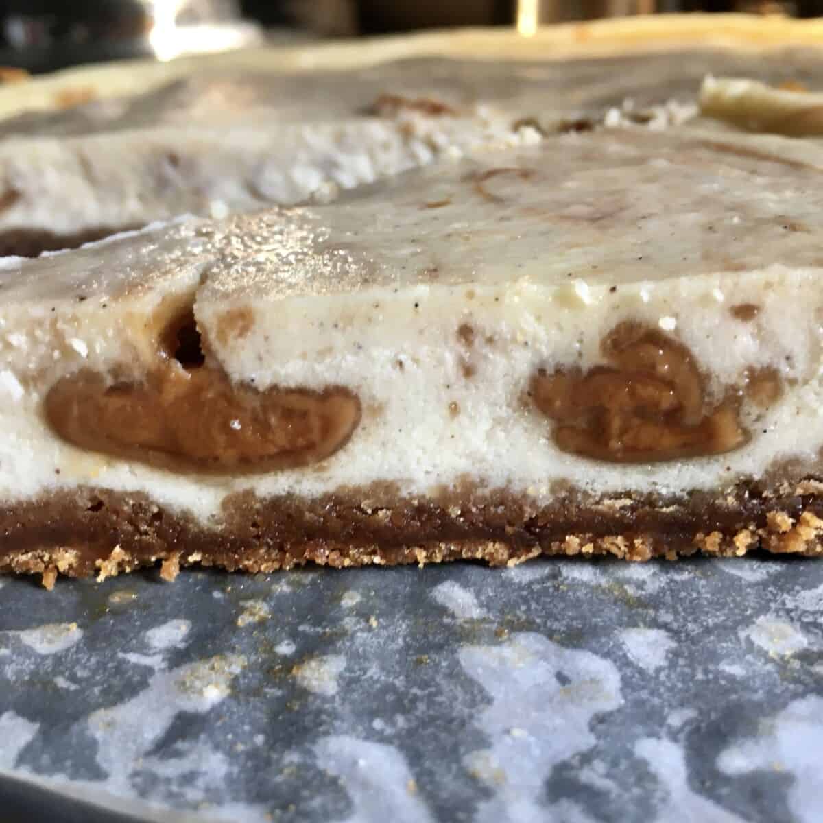 sideview of biscoff cheesecake showing 3 dots of biscoff spread in the middle