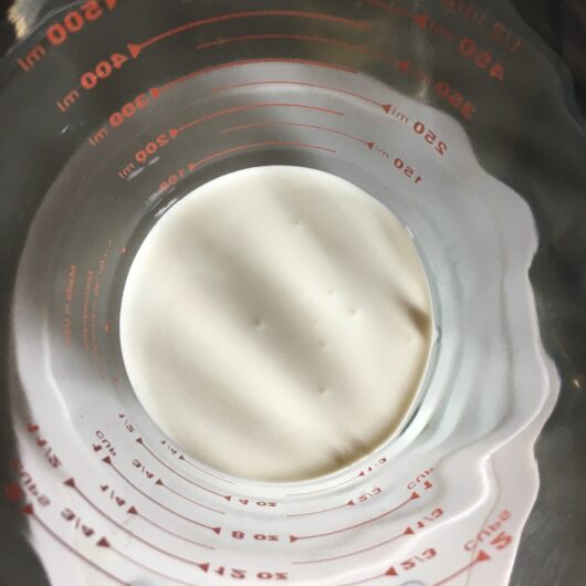 heavy cream in a measuring cup