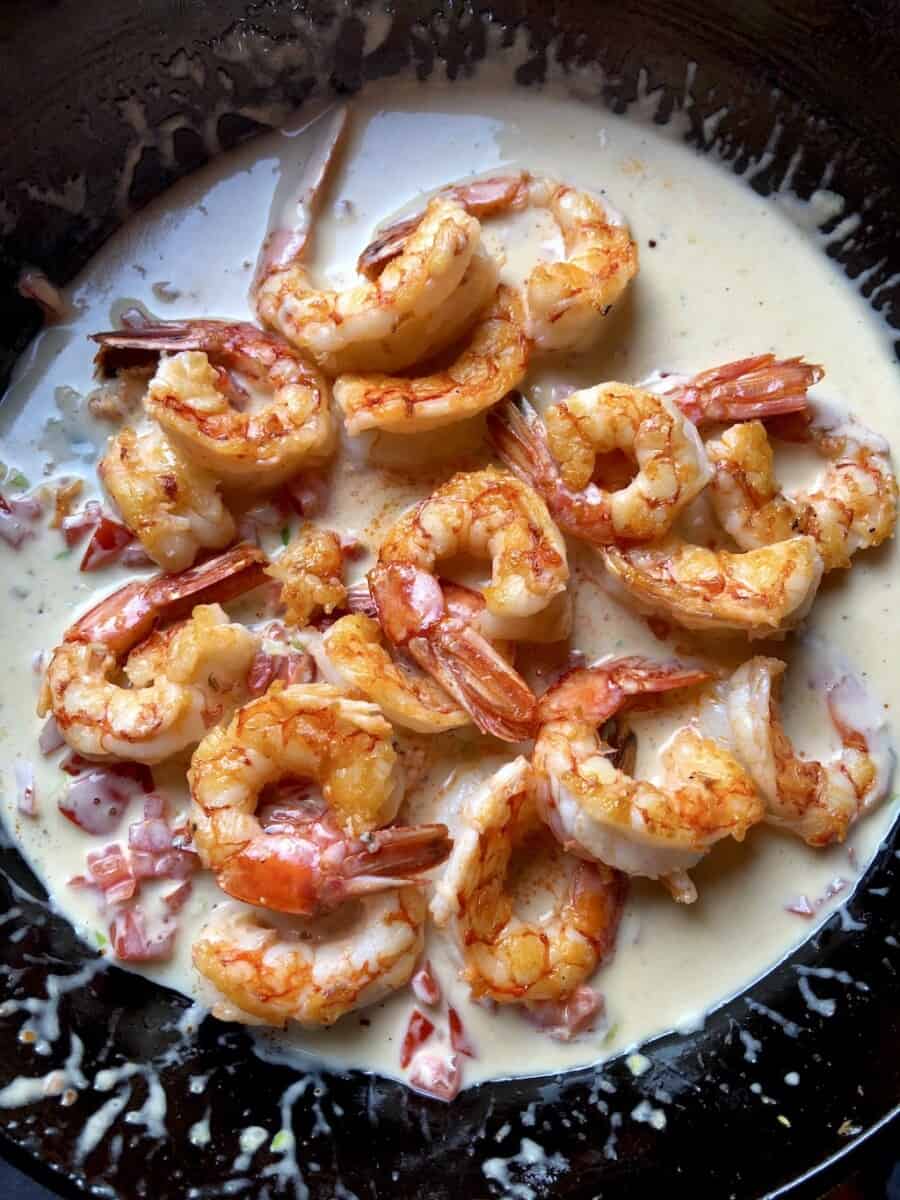 beautiful orange-red perfectly pan seared Argentinian Red shrimp placed on top of a Parmigiano Alfredo cream sauce for