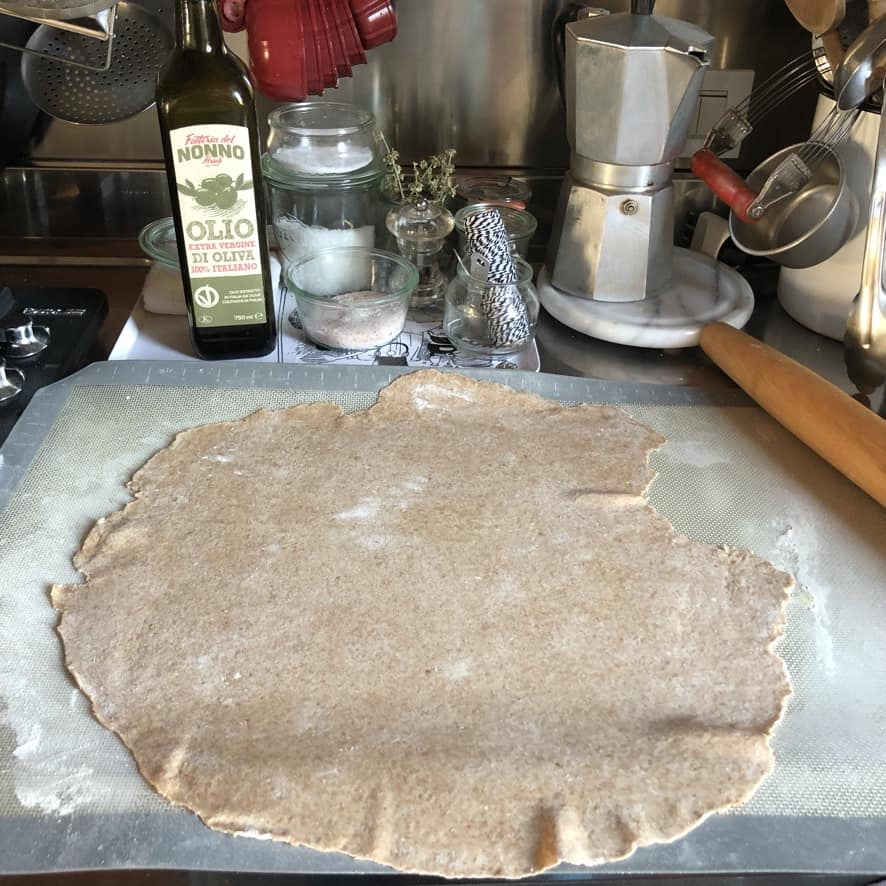 100% whole wheat flour St. Louis Style Pizza dough rolled out on a non-stick baking/rolling mat