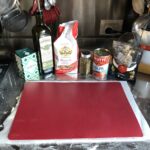 a thin red flimsy plastic cutting board/placemat placed on top of the parchment paper so the dough can be flipped over