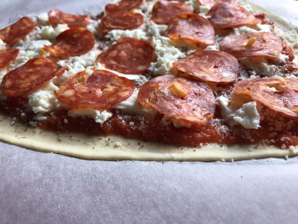 a raw beautifully trimmed pizza with pepperoni on top