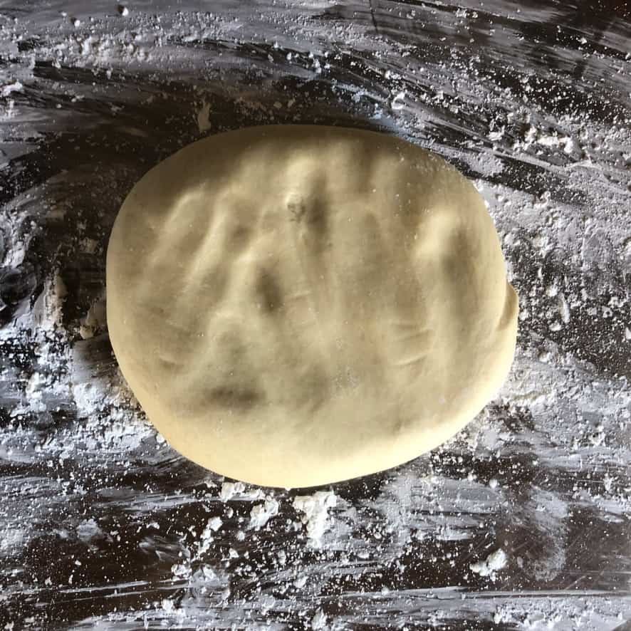 a lightly patted down disc of wonton dough on a cornstarch-dusted work surface