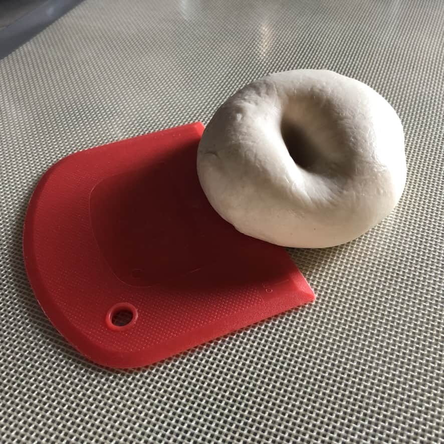very white, smooth and shiny dumpling dough with an indention in the middle where I poked my finger into it with a red chinese dough cutter slightly underneath one side