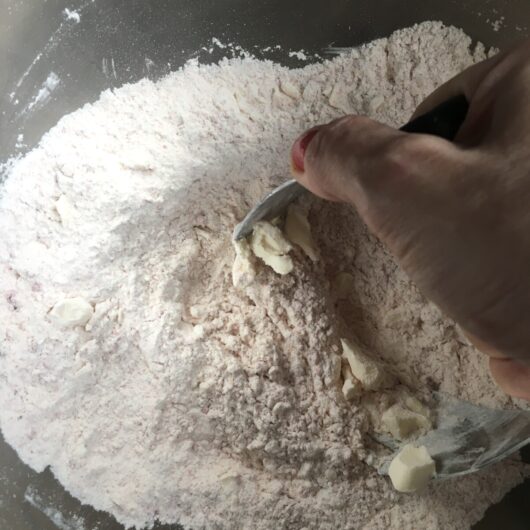 using a dough cutter to cut in the butter with the flour mixture