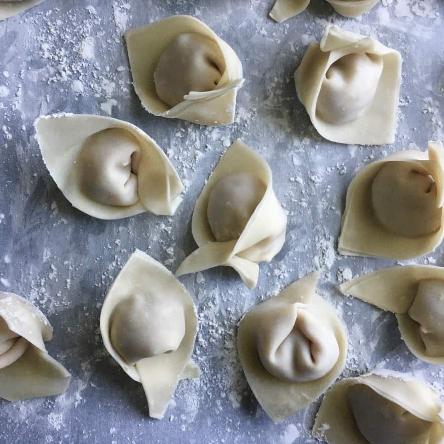 raw chinese wontons formed into the typical shape and ready to be steamed