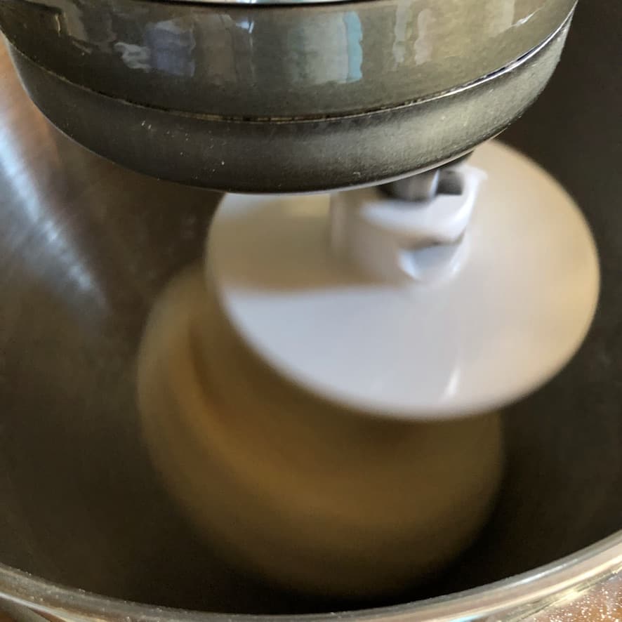 dough hook in stand mixer combining all of the wonton wrapper ingredients for the second time