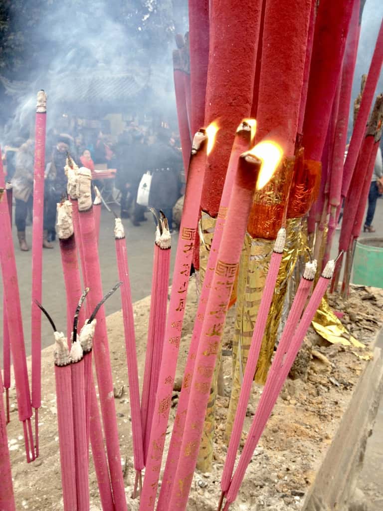 hot pink incense sticks burning in a sand pit in Chengdu, China