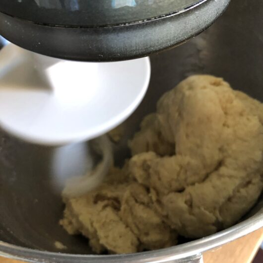 dough hook in stand mixer combining all of the ingredients