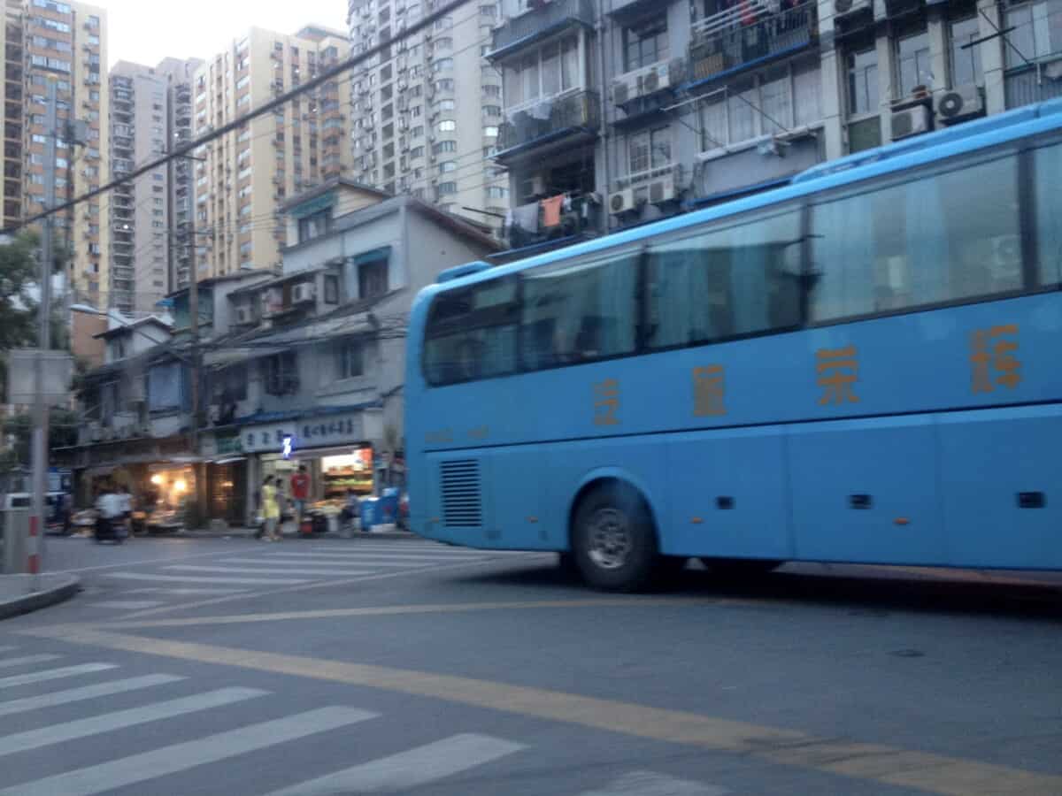 a blue bus on the street in Shanghai, China