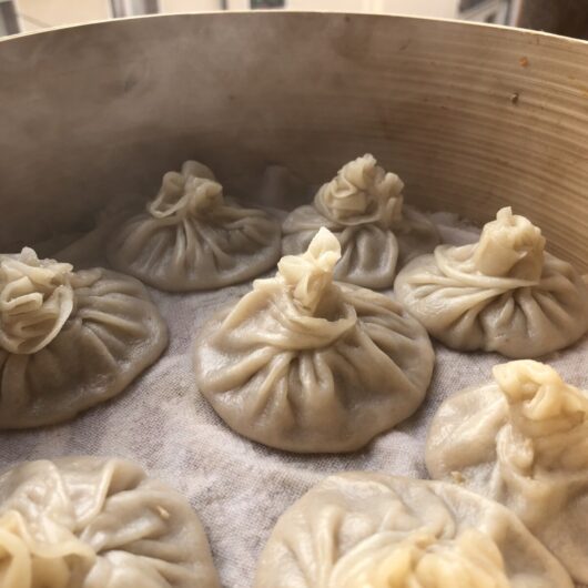 the best homemade chinese soup dumplings xiaolongbao (小笼包) just steamed and still sitting in the bamboo steamer