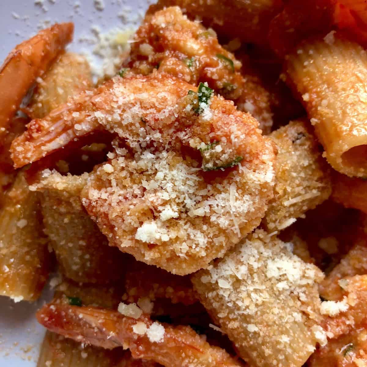 Creamy Argentinian shrimp pasta with rigatoni in tomato cream sauce alfredo topped with grated Grana Padano parmesan cheese, creamy shrimp pasta recipe.