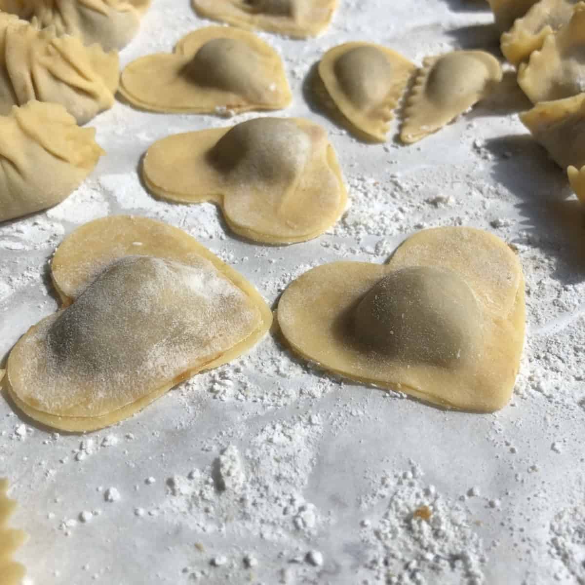 A sealed heart-shaped pork wonton ready to cook, how to make wontons in custom shapes with homemade wonton wrapper dough.