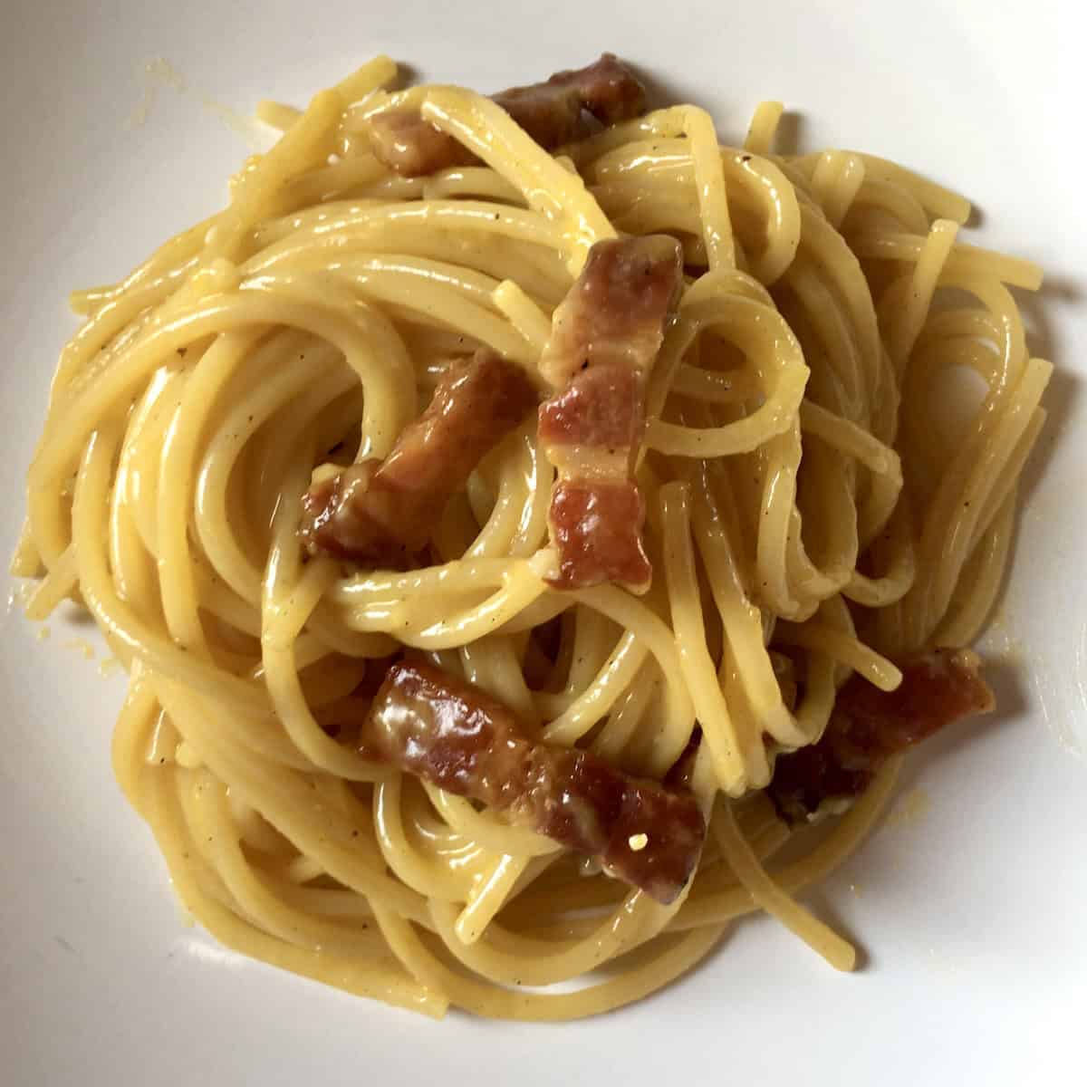 Spaghetti alla carbonara with pancetta, pasta carbonara recipe with egg and black peppe (not authentically used in carbonara, but widely used by Italian home cooks for a guanciale substitute.