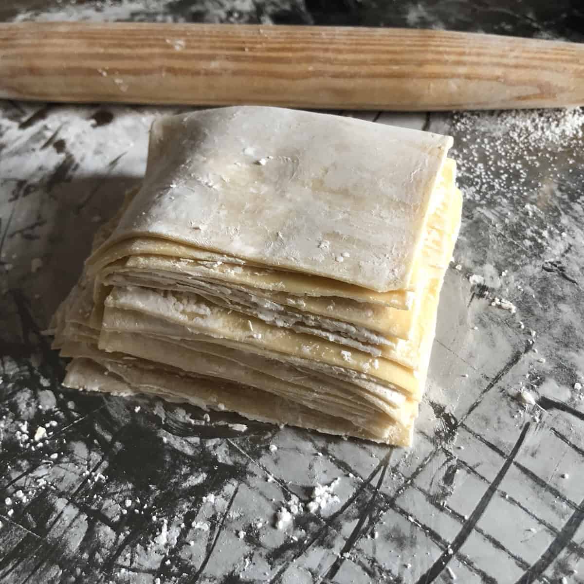 
A large stack of homemade wonton wrappers ready to fill, wonton wrappers you can make at home for wontons, dumplings, or wonton chips.
