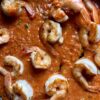 pan seared shrimp in a pan full of cream tomato alfredo