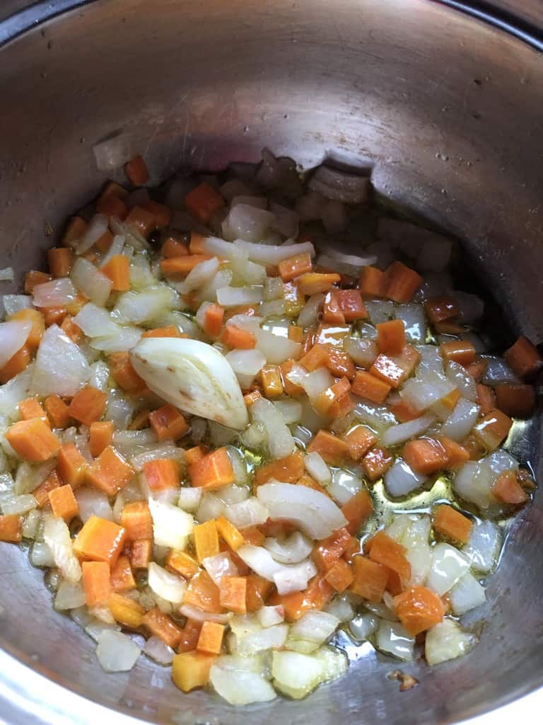 diced onions, carrots, and smashed garlic clove softened while cooking in a pot with olive oil