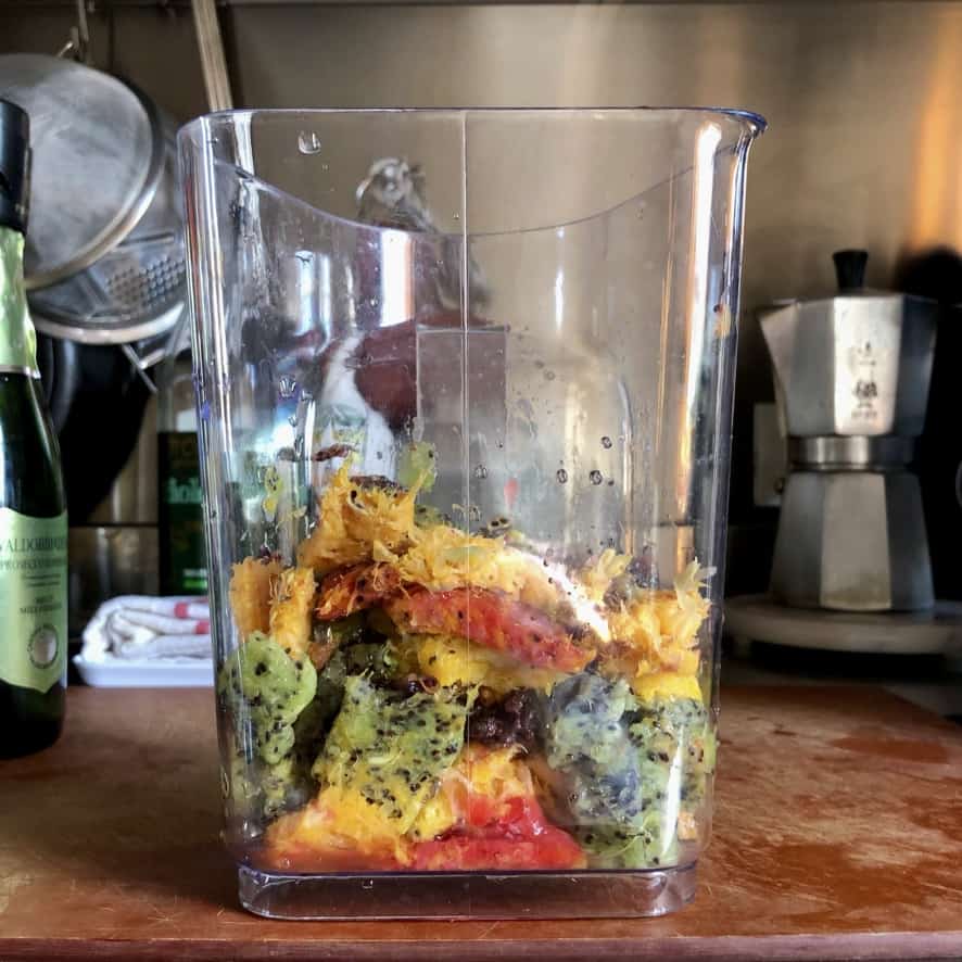 a juicer carafe filled with the leftover fruit pieces from juicing (it's looks like it's own rainbow)