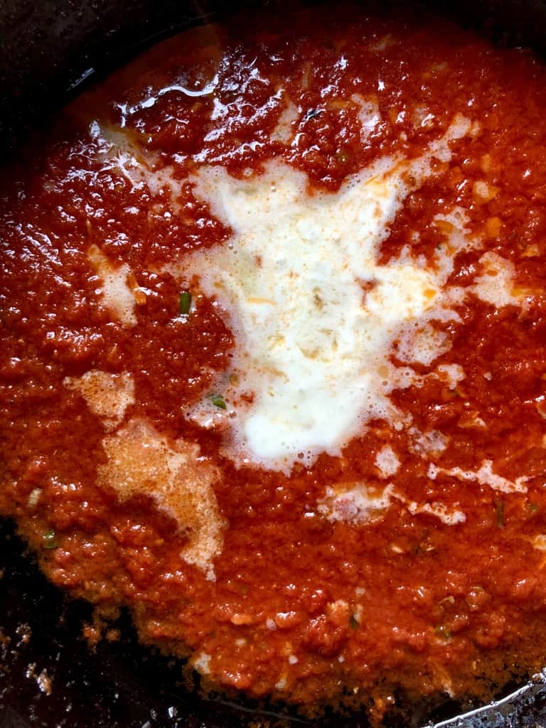 deep red tomato sauce with a "puddle" of heavy cream just added
