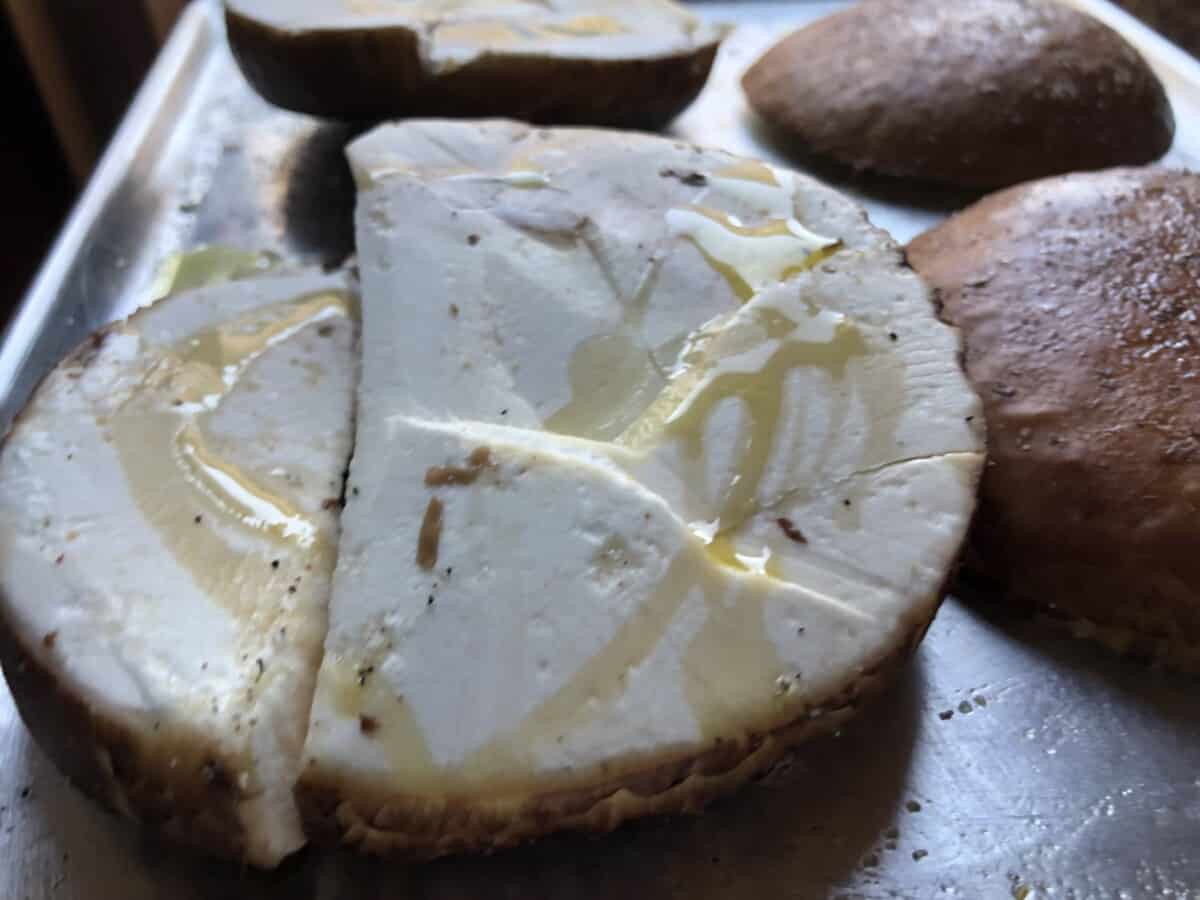 EVOO drizzled over a closeup of a horizontally sliced portobello mushroom