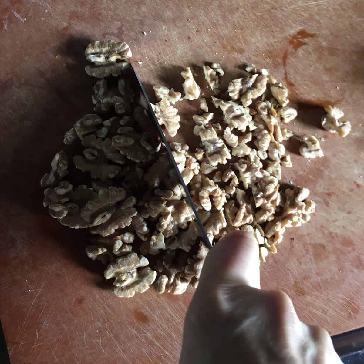 Freshly toasted walnuts chopped and ready to fold into a moist carrot and walnut cake batter.
