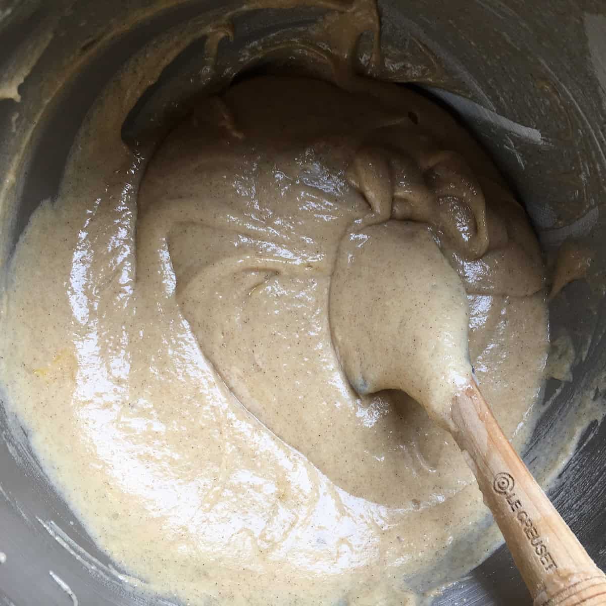 A fully cohesive carrot cake batter in a stand mixer bowl, smooth and ready for the freshly grated carrots to be folded in.
