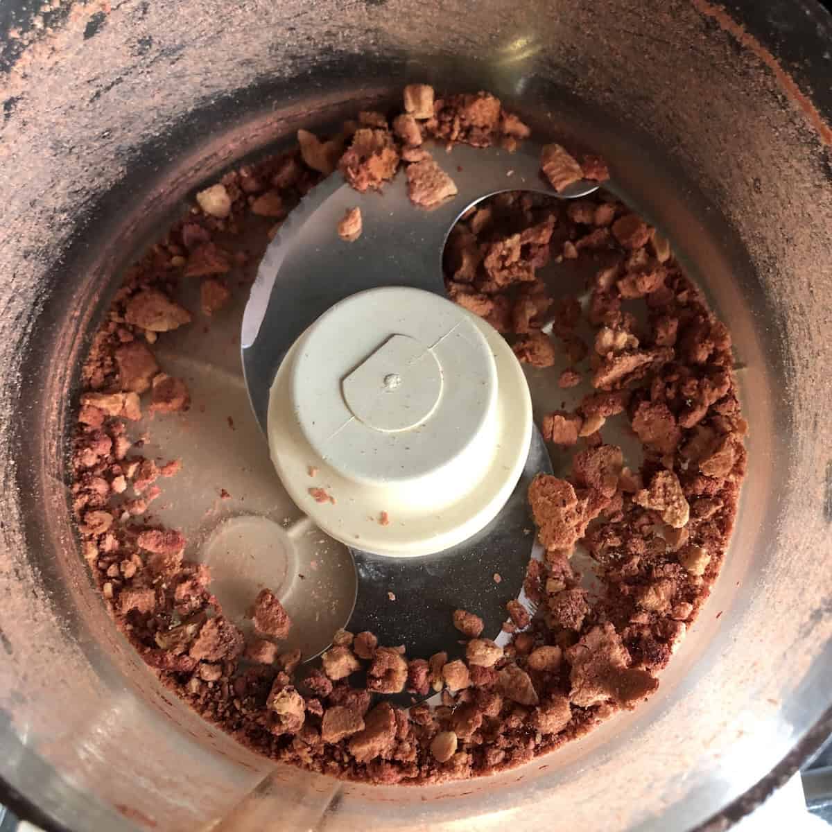 Freeze-dried strawberries processed in a food processor with some pulverized and some broken into larger pieces.
