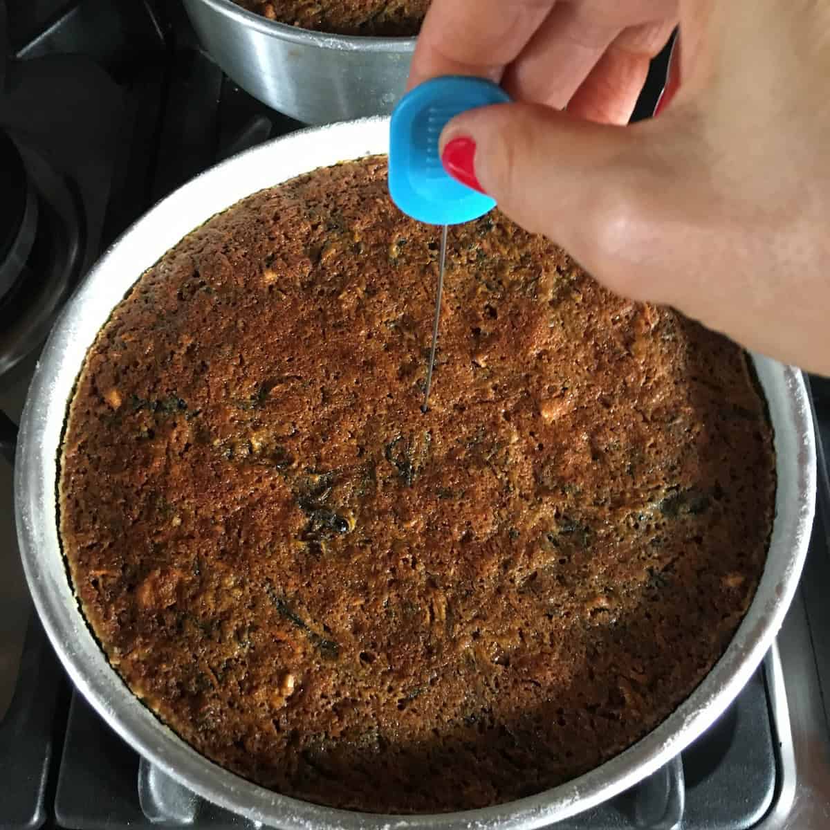 An Ateco cake tester inserted into the center of a carrot cake to check doneness - one of the most common carrot cake mistakes is pulling it from the oven too soon.
