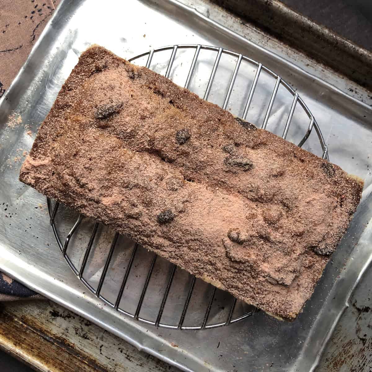 Strawberry banana bread dusted with homemade powdered strawberry sugar on a cooling rack after fully cooling.
