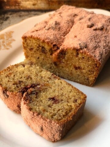 Sliced strawberry banana bread dusted with homemade powdered strawberry sugar on a plate, strawberry banana bread recipe.