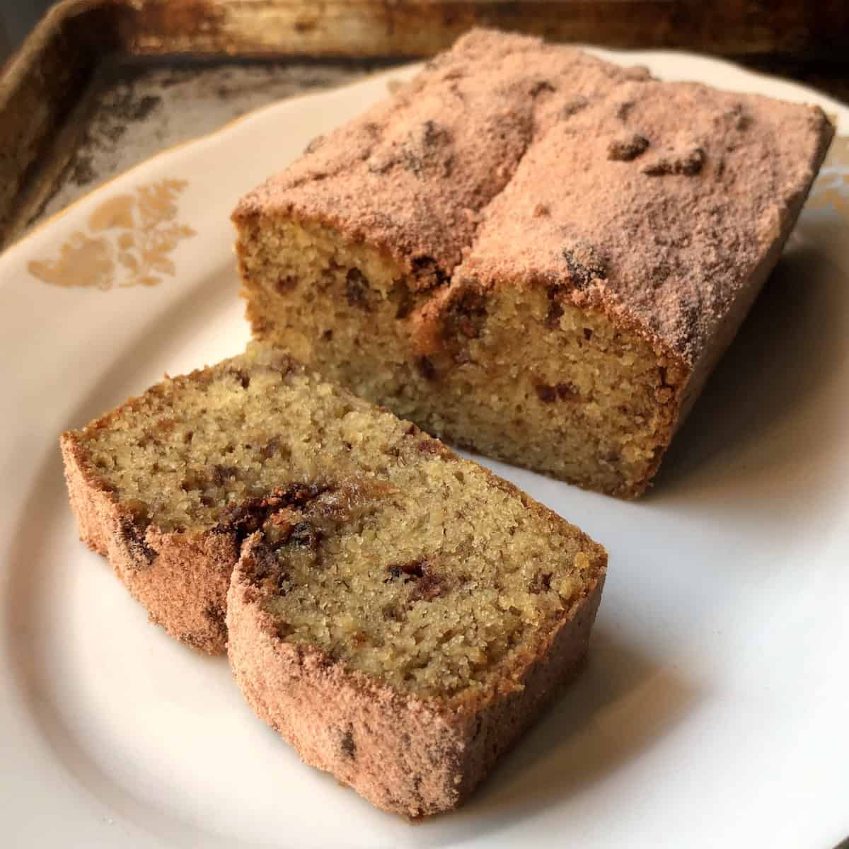 Sliced strawberry banana bread dusted with homemade powdered strawberry sugar on a plate, strawberry banana bread recipe.