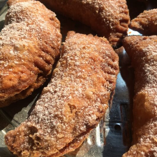 crispy flaky golden brown strawberry-rhubarb fried pies sprinkled with homemade strawberry sugar