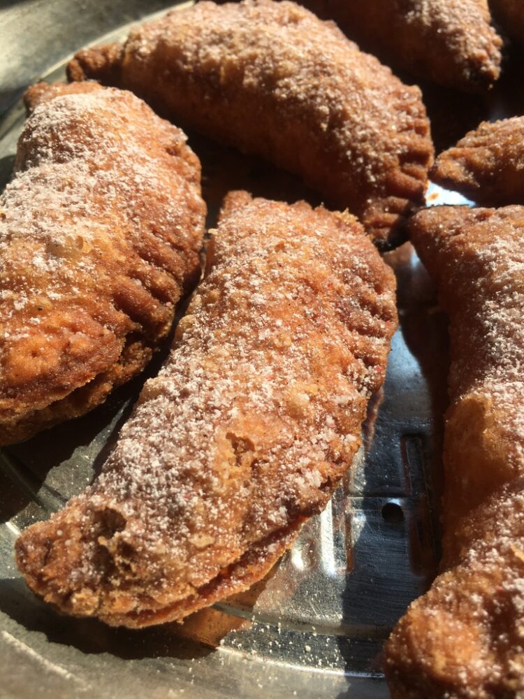 crispy flaky golden brown strawberry-rhubarb fried pies sprinkled with homemade strawberry sugar
