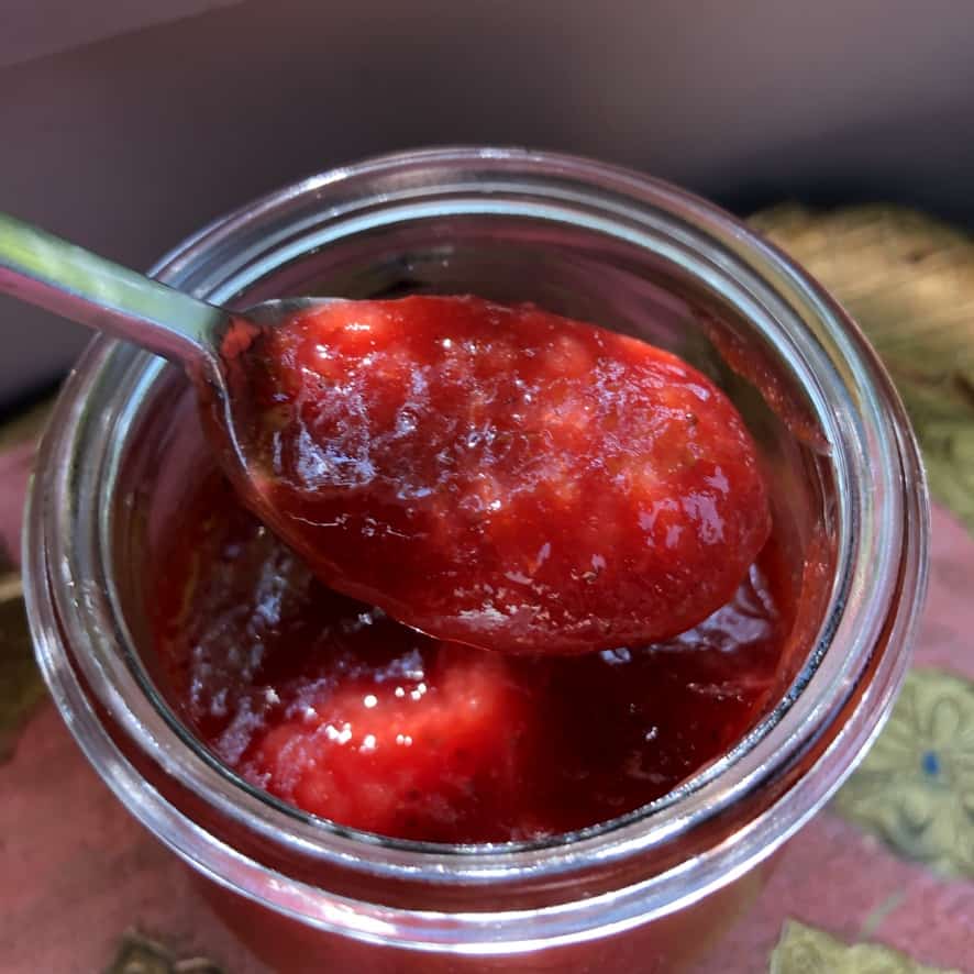 a spoon in the jar with strawberry blood orange sauce