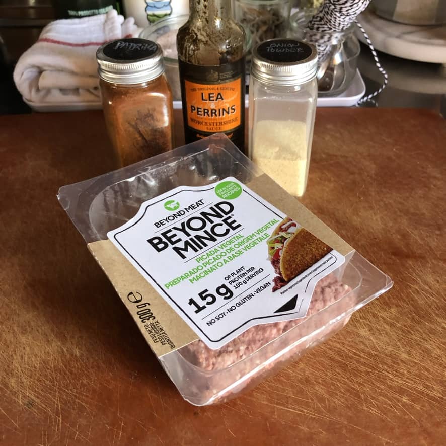 Beyond Mince "meat" and burger seasoning ingredients on a cutting board