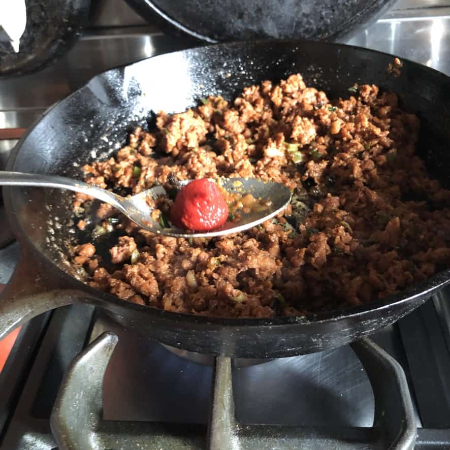 Adding tomato paste to sauteed beyond taco meat.