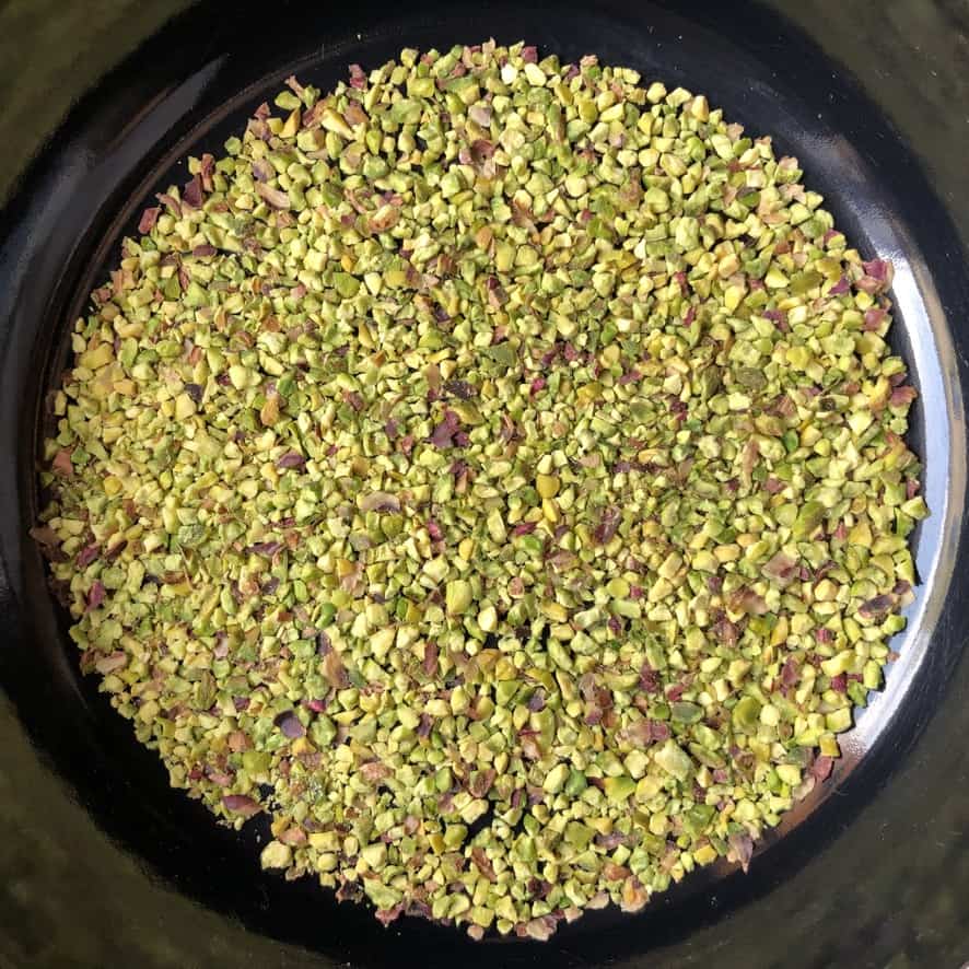chopped Sicilian pistachios in a braiser pan about to be toasted
