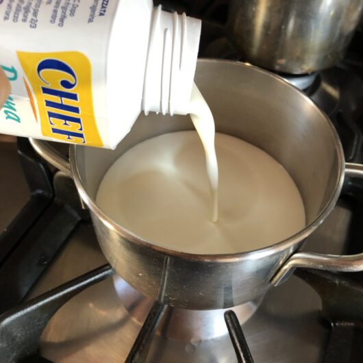 adding heavy cream to a small pot