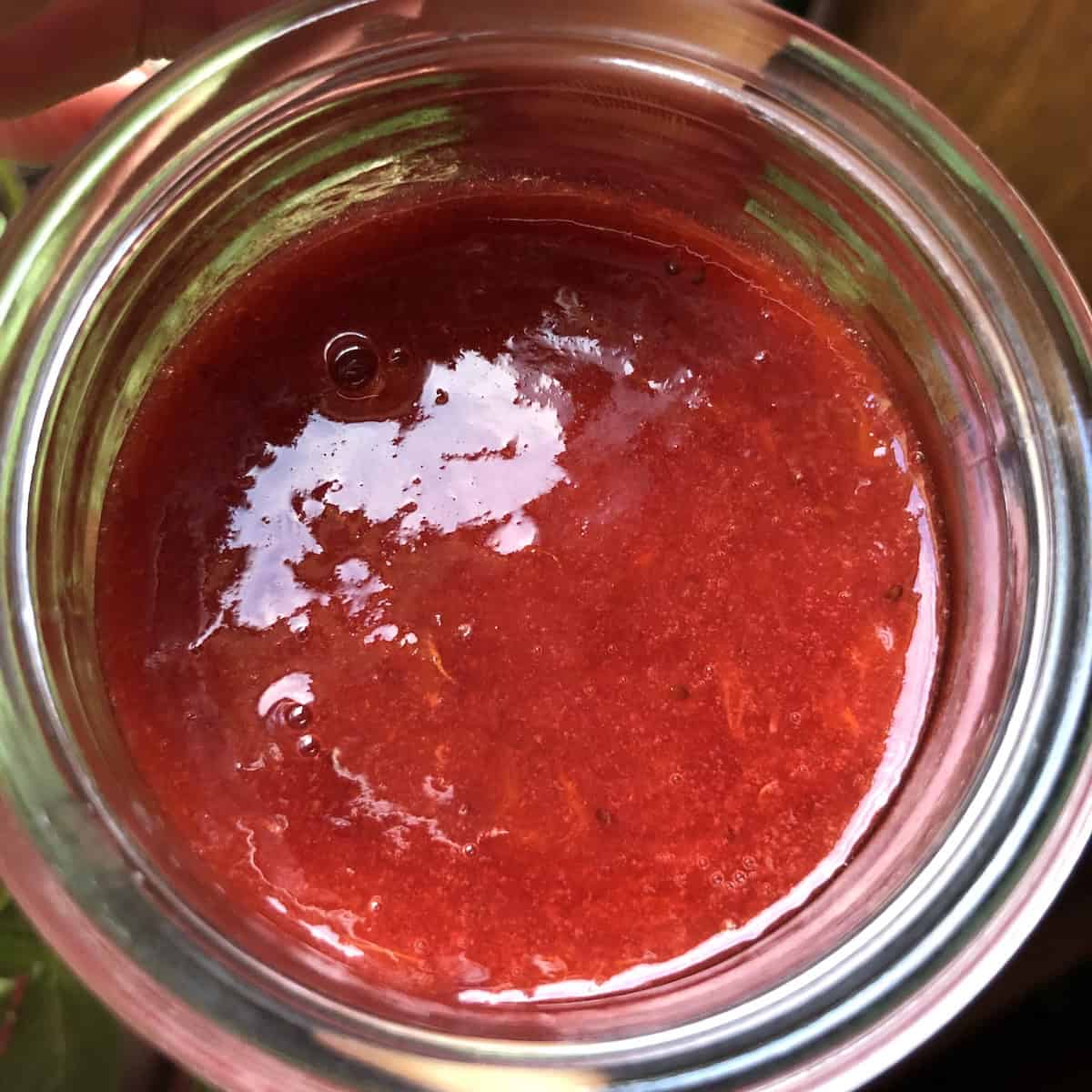 Strawberry blood orange topping in a glass jar, a versatile fruit sauce for desserts and breakfast.