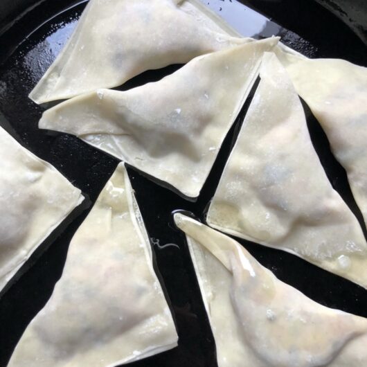 raw potstickers in a cast iron skillet