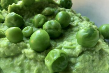 bright green mushy peas with whole peas dotted on top