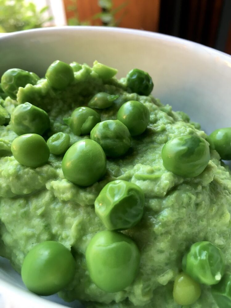 bright green mushy peas with whole peas dotted on top