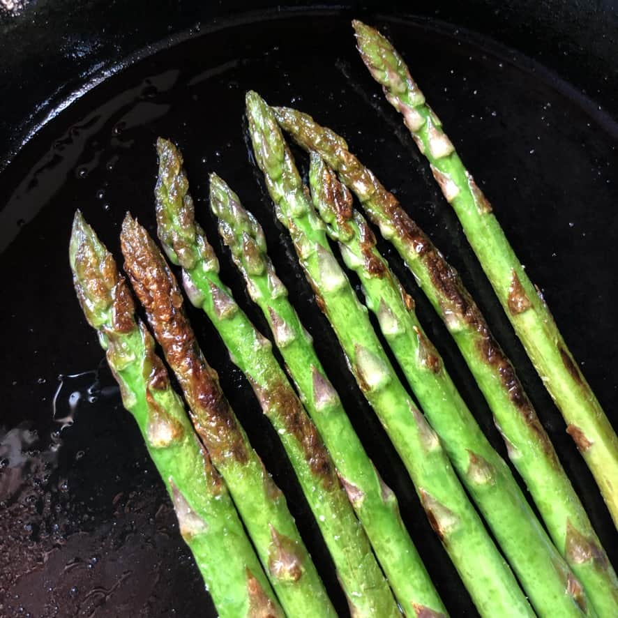 pan-seared asparagus in a cast iron skillet.