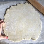 pie dough rolled out on a baking mat