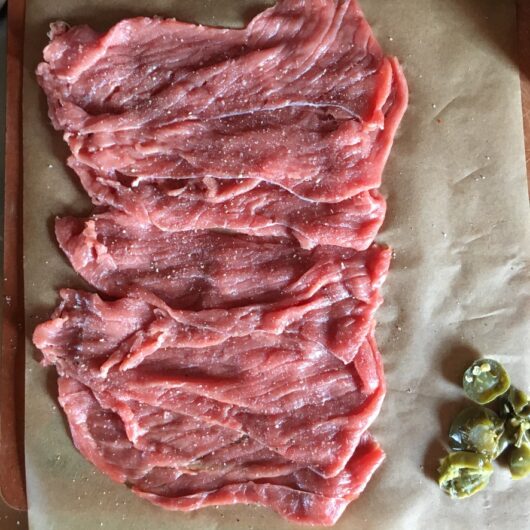raw shaved beef on a cutting board