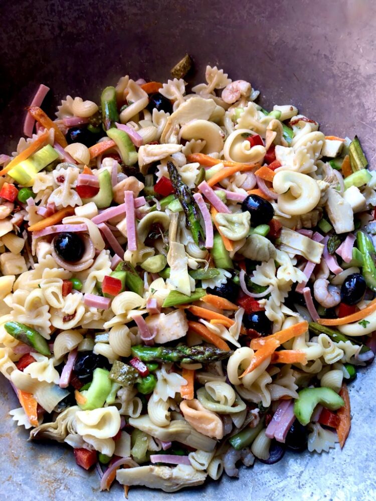 Mediterranean pasta salad with pasta, olives, fresh mozzarella, shrimp, sauteed asparagus and carrots, sun dried tomatoes, celery, cucumbers, and more.
