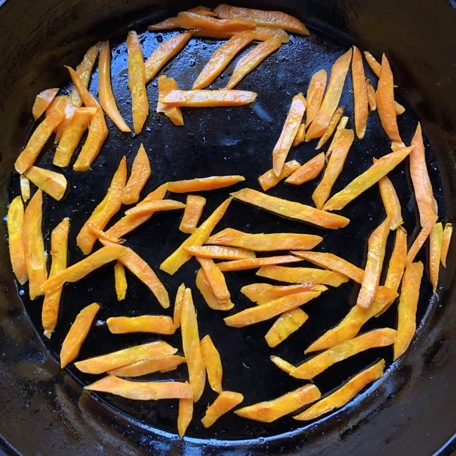 pan-seared sweet julienned carrots in a cast iron skillet.
