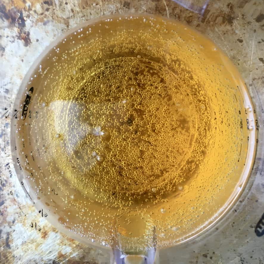 golden beer in a clear liquid measuring cup top-down view