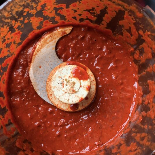 deep bright red-orange smooth homemade al pastor sauce in a food processor
