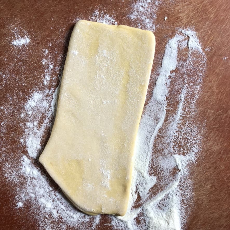 getting one nice cohesive piece of dough ready to be cut in half and each piece rolled through the pasta machine until desired thinness